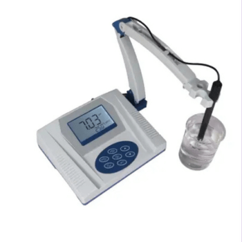 Benchtop digital pH meter with an electrode on a swing arm dipped in a beaker of clear liquid